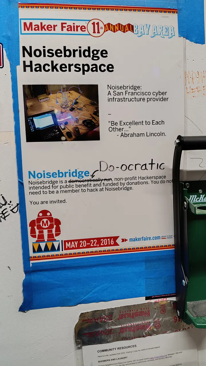 A poster for the 2016 Maker Faire hosted at Noisebridge Hackerspace, where the printed word "democratically" has been crossed out and replaced with the handwritten word "Do-ocratic".